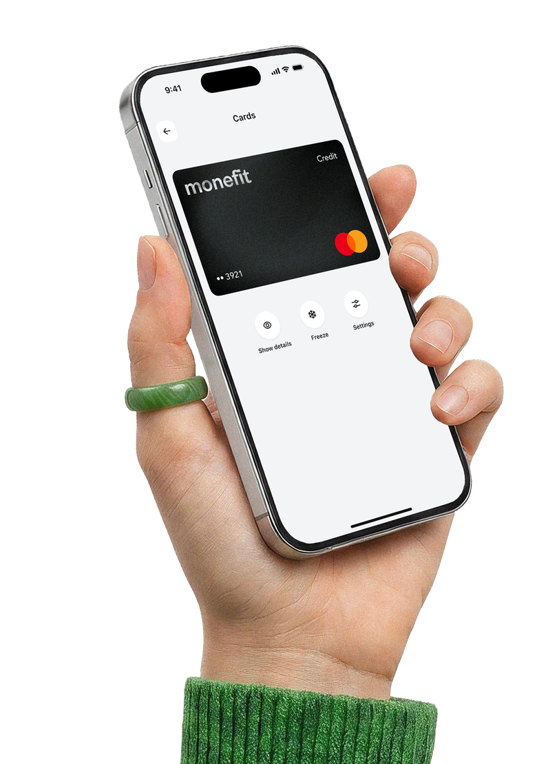 Hand holding a phone showing the Monefit app